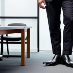 **Image Prompt 1: Professional Shoes for Business Meetings**
   - A well-dressed man wearing polished black leather shoes, standing confidently in a formal meeting room. The focus is on the shoes, highlighting their elegance and professional appearance. The background shows a stylish office setting with a conference table and a modern design.